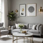 Современная гостиная в серых тонах с золотыми акцентами, диваном, креслом и журнальным столиком.