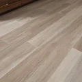 Изображение, демонстрирующее идеально установленный порожек между двумя напольными покрытиями – ламинатом и крупноформатной плиткой, подчеркивающее эстетику и долговечность пола в современном интерьере.