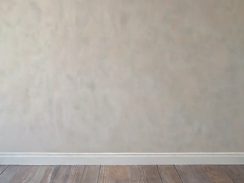 Фотореалистичный вид крупным планом идеально гладкой, отшлифованной поверхности гипсокартона, готовой под покраску или поклейку обоев, демонстрирующий финальный штрих и безупречную гладкость.