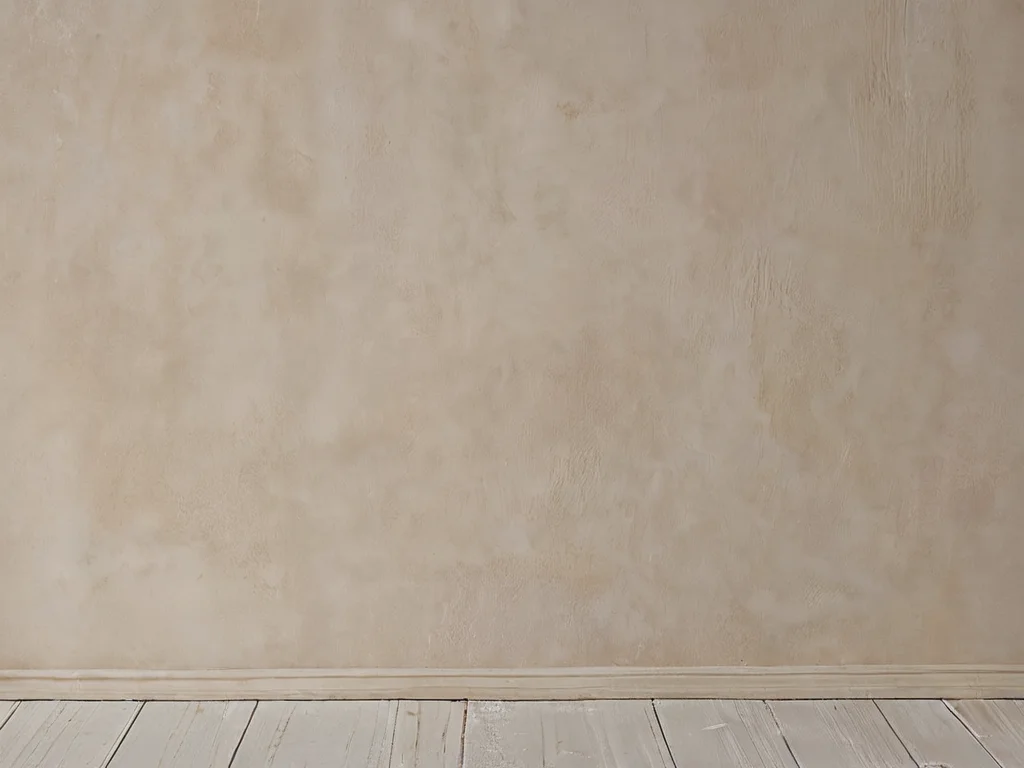 Крупный план идеально гладкой стены, покрытой финишной шпаклевкой, с едва заметной текстурой, демонстрирующей секреты идеального финиша.